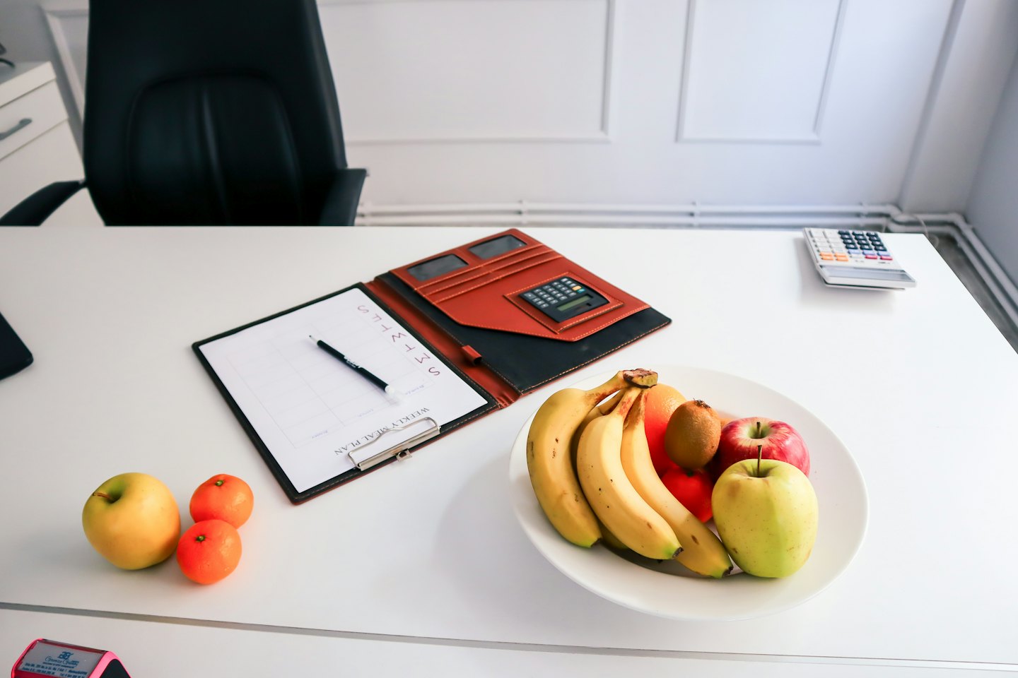 Office desk with fruit plate and meal plan.